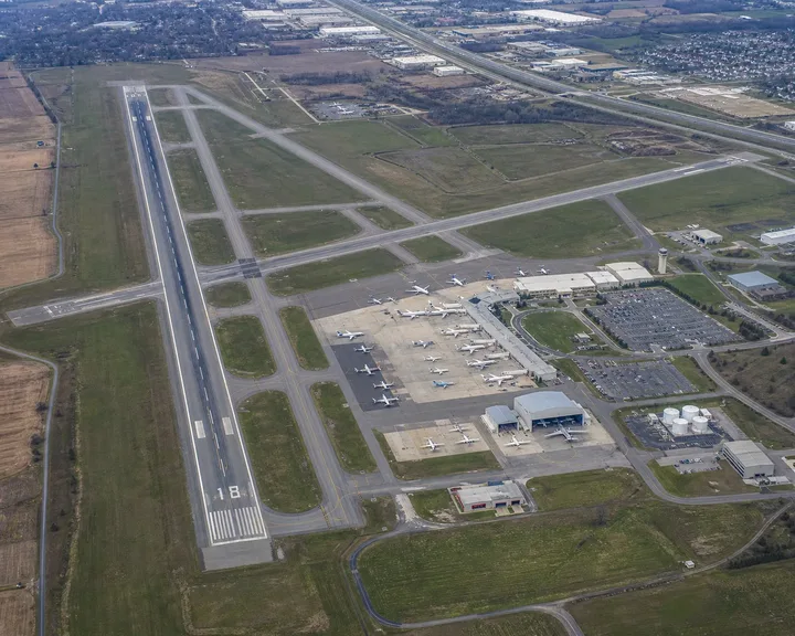 Aerial view of a midsize airport with runway, terminal apron and parked aircraft