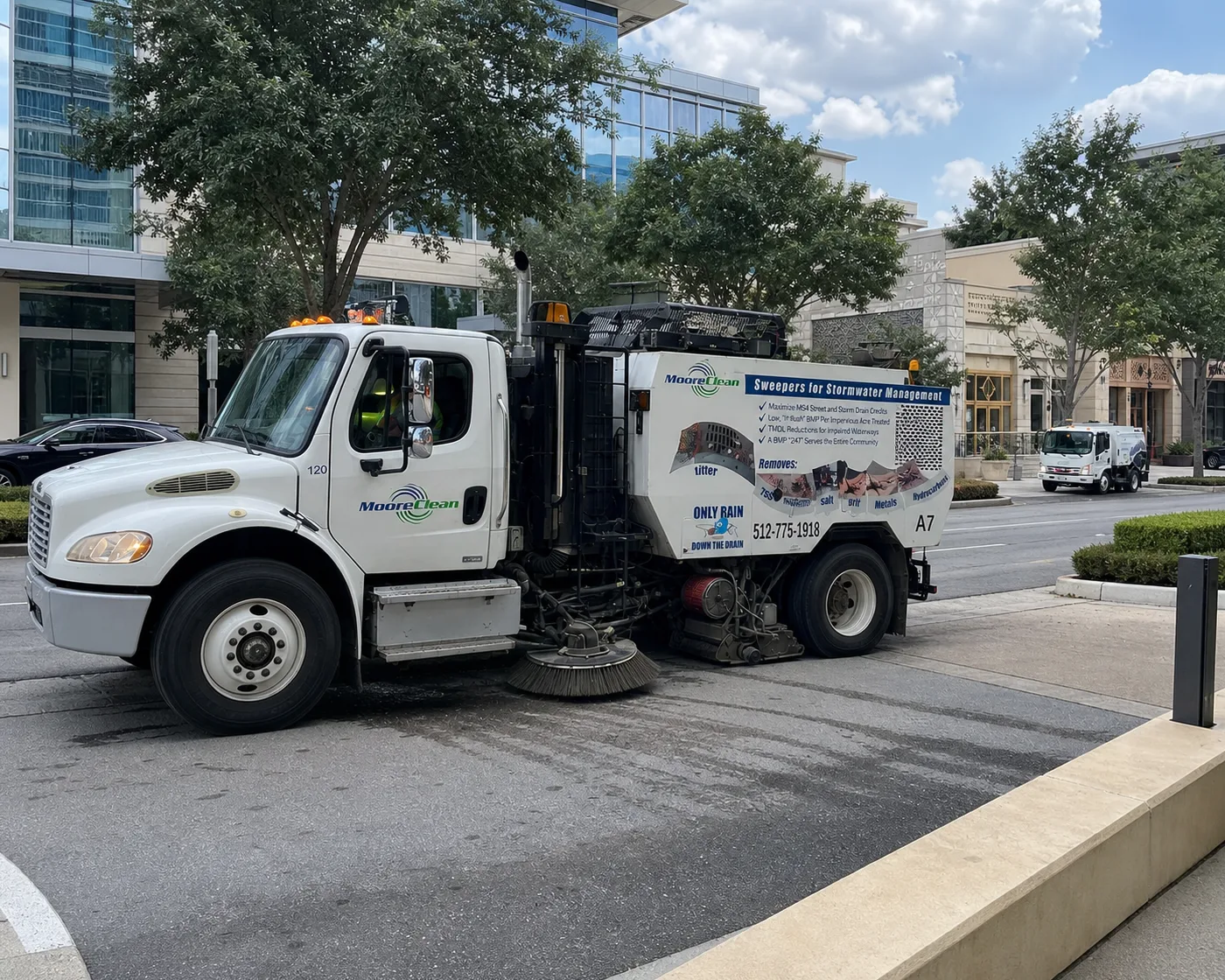Moore Clean Schwarze A7 sweeper working a daytime route at an Austin corporate retail plaza